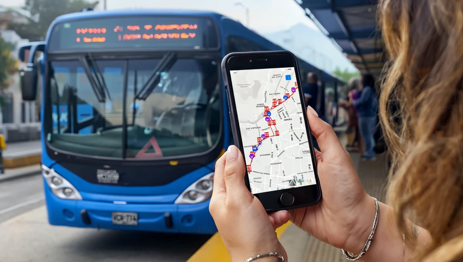 Foto donde se ve unas manos sosteniendo un celular y el trazado de una ruta y al fondo un bus del MIO.