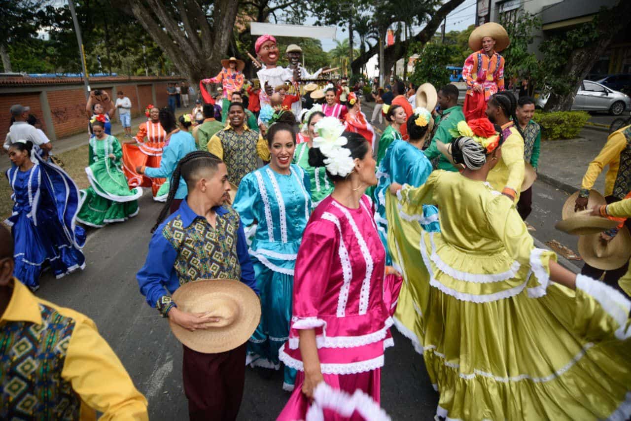 Foto en la cual se observa a personas con trajes coloridos en un desfile.